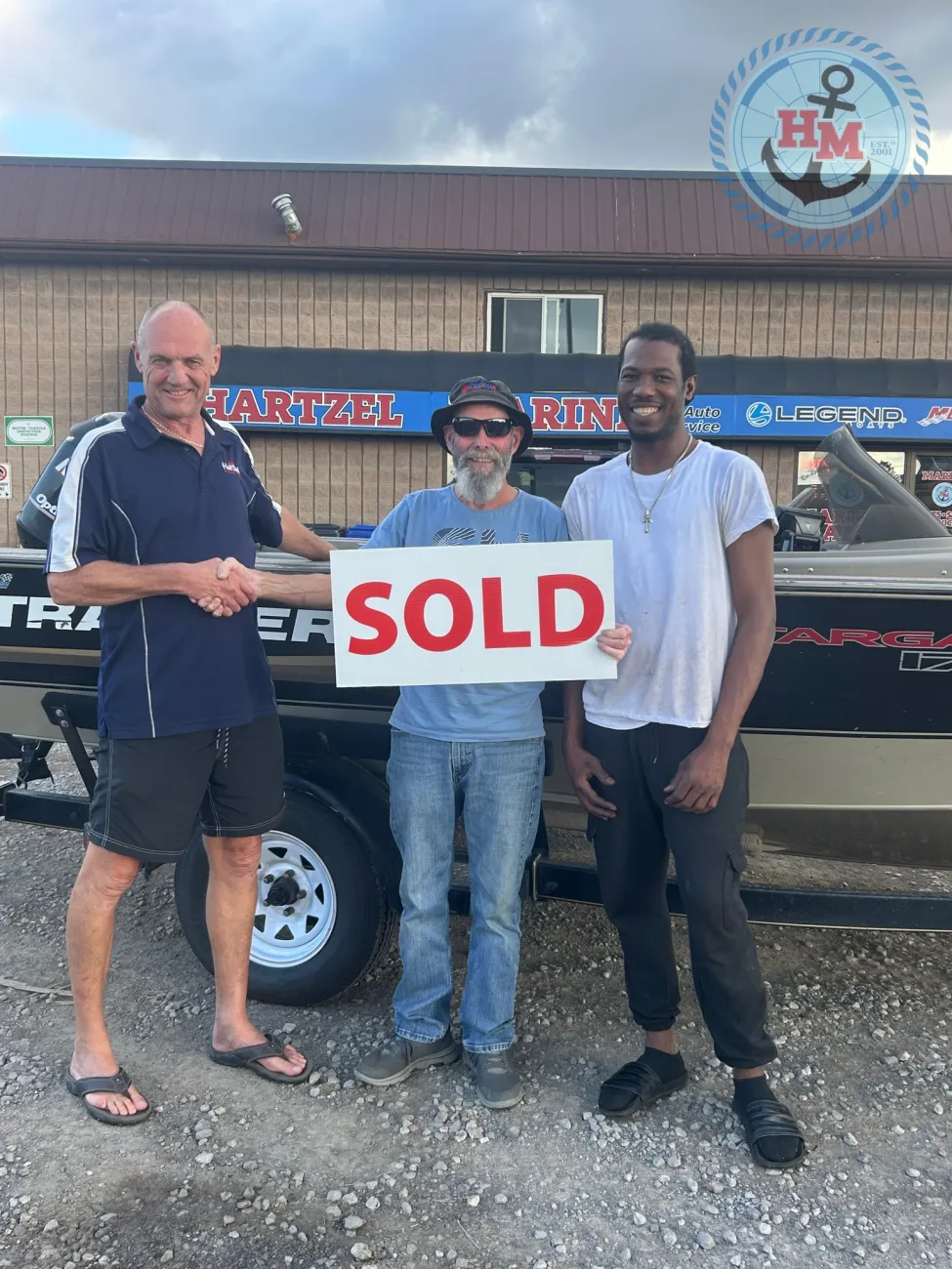 Hartzel Marine customer with their newly purchased Legend boat and a SOLD sign