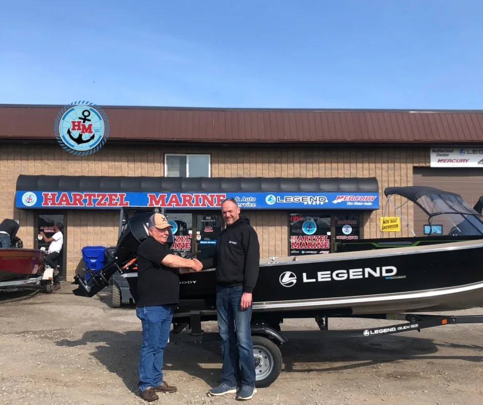 Customer shaking hands at the Hartzel Marine storefront after a boat purchase