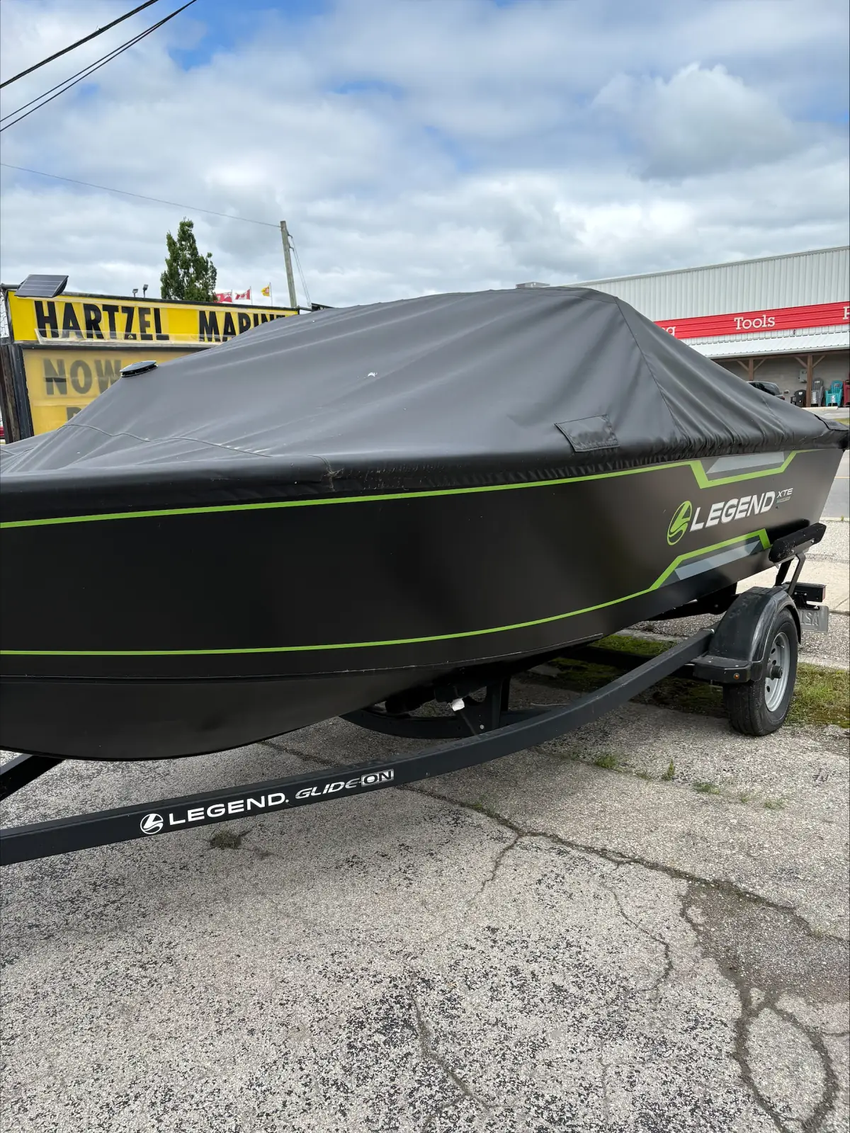 2023 Legend XTE Sport 18 under its travel cover outside the Hartzel Marine shop