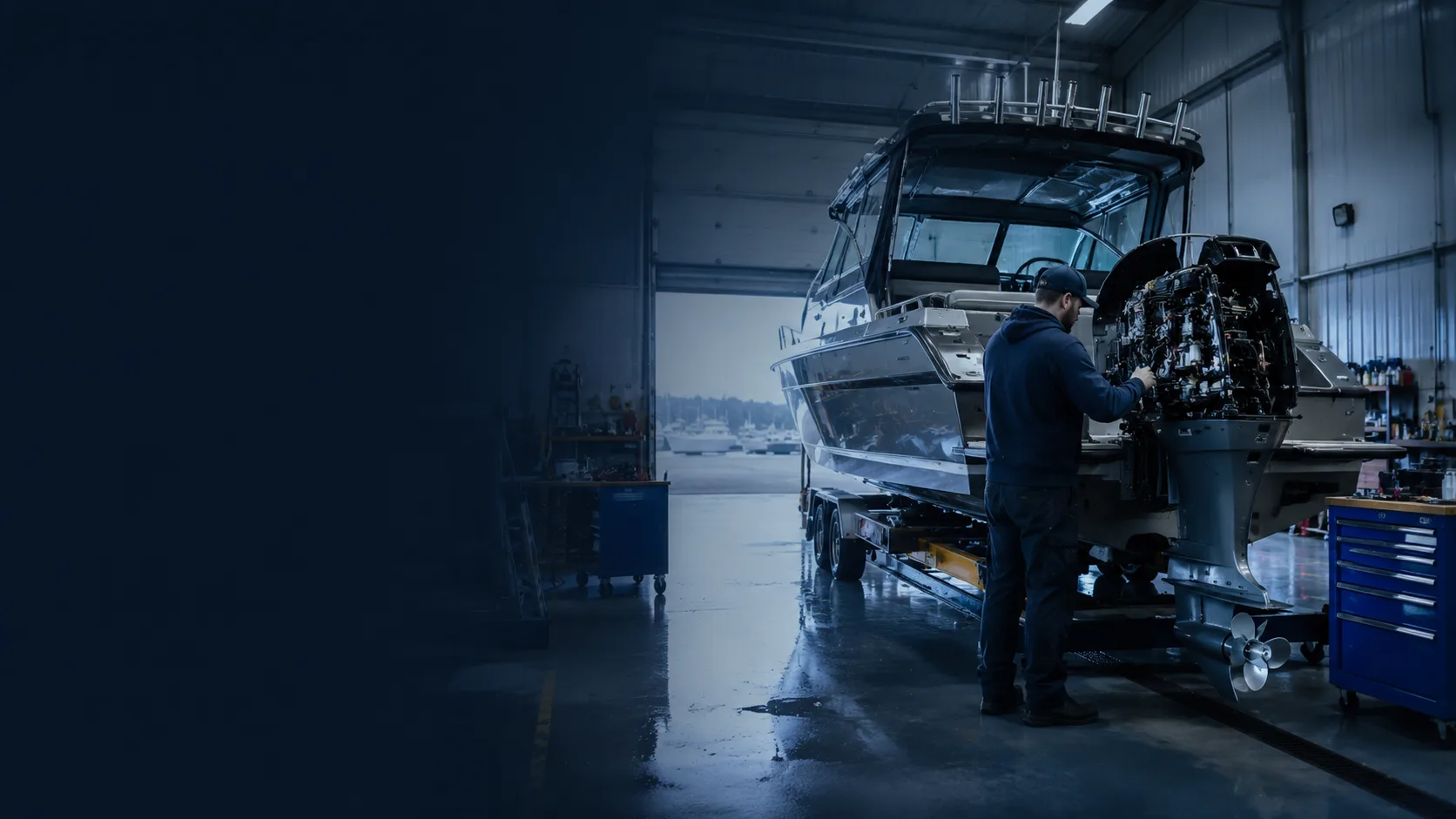 Technician servicing an outboard engine on a boat in the Hartzel Marine shop bay