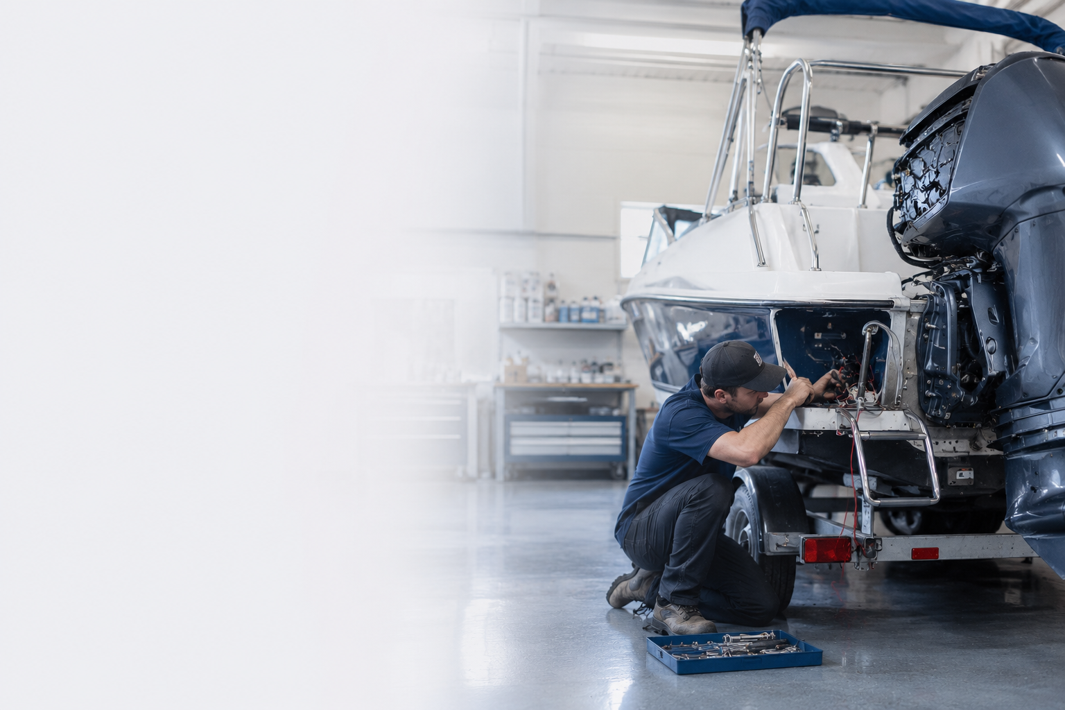 Marine technician diagnosing an outboard in the shop bay