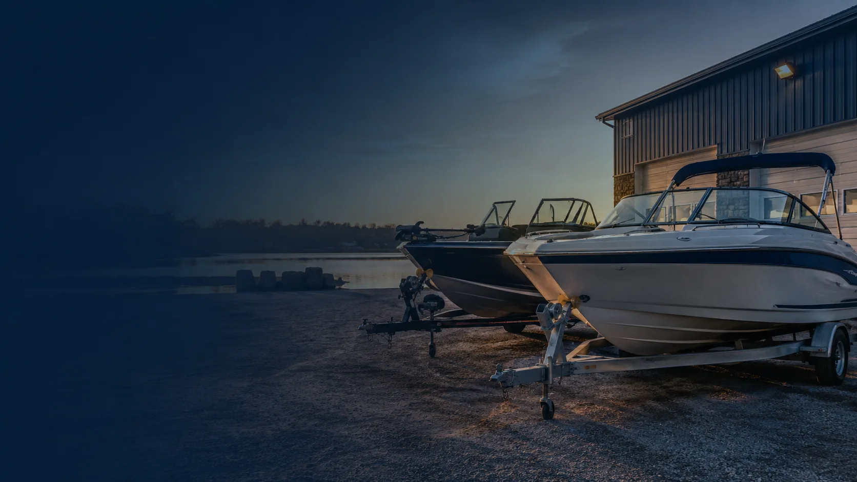 Used boats on trailers at sunset outside the Hartzel Marine shop on the Grand River