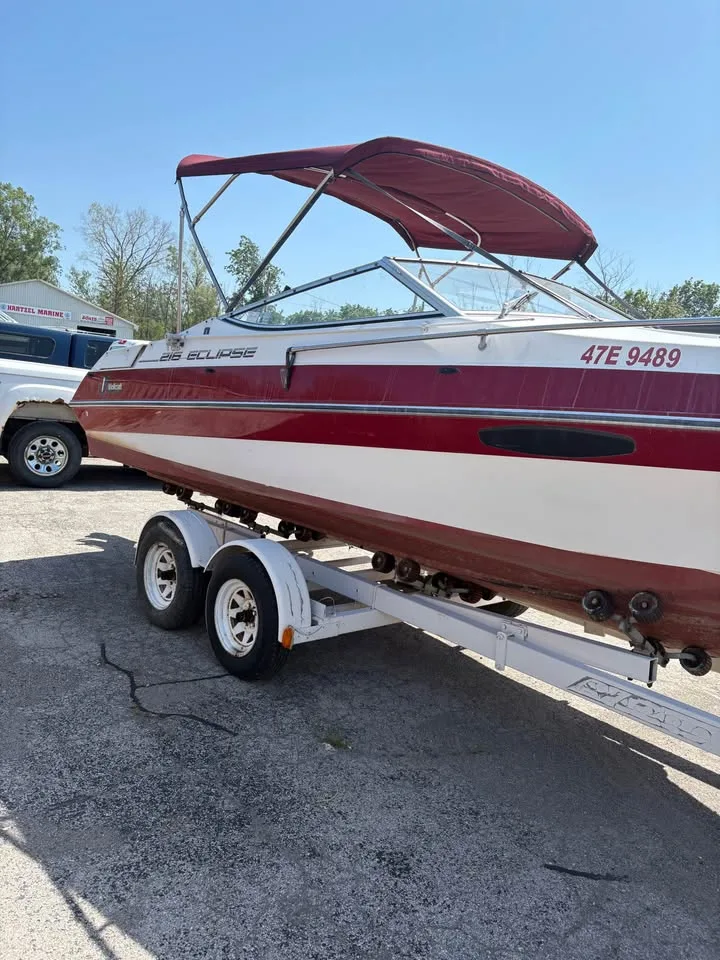 1991 Wellcraft 216 Eclipse on its trailer, red and white hull with bimini up